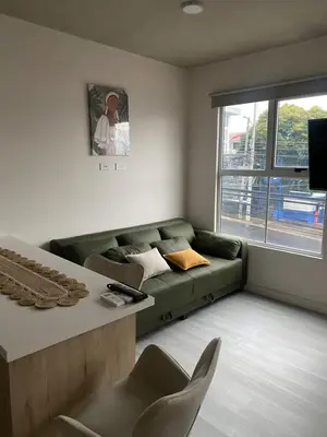 a living room with a green couch and a window at Hermoso y Acogedor Studio Sabana, San Jose in San José