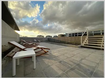 a patio with two lounge chairs on top of a building at Hermoso y Acogedor Studio Sabana, San Jose in San José