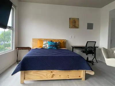 a bedroom with a bed with a blue comforter at Hermoso y Acogedor Studio Sabana, San Jose in San José