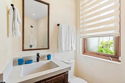 a bathroom with a sink and a mirror and a toilet at Stylish Condo in the Heart of Las Catalinas with Vibrant Design & Exclusive Beach Club Access in Playa Danta