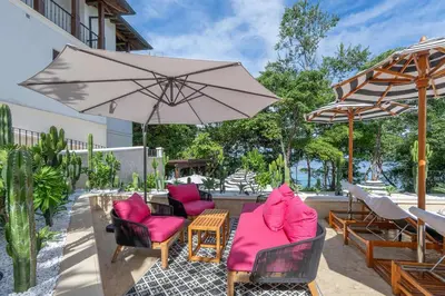 a patio with two chairs and an umbrella at Stylish Condo in the Heart of Las Catalinas with Vibrant Design & Exclusive Beach Club Access in Playa Danta