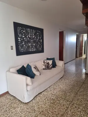a white couch sitting in a living room at Linda y céntrica habitación in Alajuela City