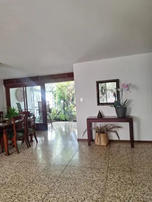 a living room with a table and a dining room at Linda y céntrica habitación in Alajuela City