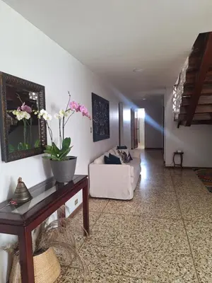 a living room with a couch and a table with flowers on it at Linda y céntrica habitación in Alajuela City