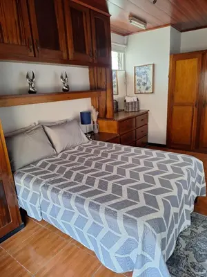 a bedroom with a large bed with wooden cabinets at Linda y céntrica habitación in Alajuela City