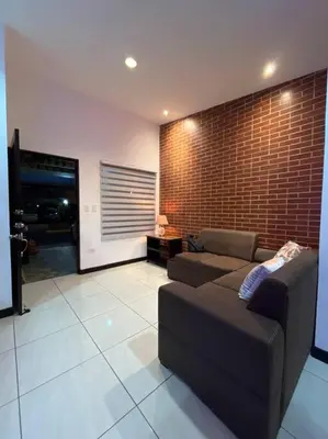 a living room with a couch and a brick wall at Hermosa Casa con todos los servicios a la mano in Barrancas