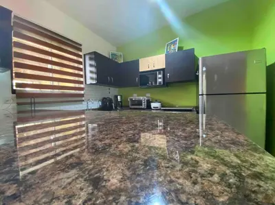 a kitchen with a stainless steel refrigerator and green walls at Hermosa Casa con todos los servicios a la mano in Barrancas