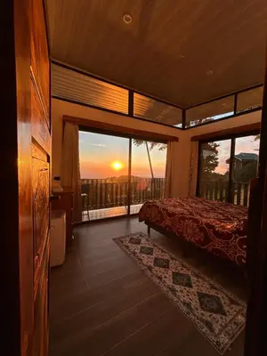 a bedroom with a bed and a view of the sunset at Athila Ecolove in Monteverde Costa Rica
