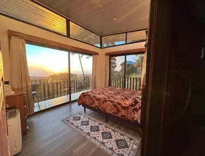 a bedroom with a bed and a balcony with a view at Athila Ecolove in Monteverde Costa Rica