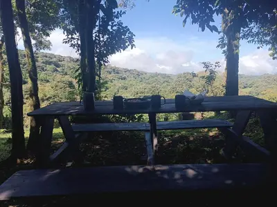 a wooden picnic table with a view of the mountains at Athila Ecolove in Monteverde Costa Rica
