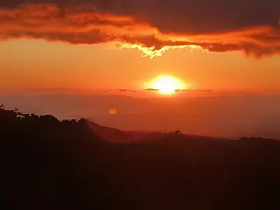 a sunset with the sun setting in the sky at Athila Ecolove in Monteverde Costa Rica