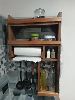 a wooden shelf with paper towels and cooking utensils at Athila Ecolove in Monteverde Costa Rica