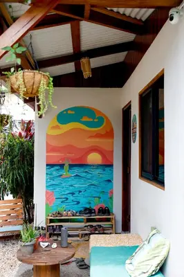 a mural on the wall of a house with a sunset at The Cafecito Surfhouse - Santa Teresa in Santa Teresa Beach