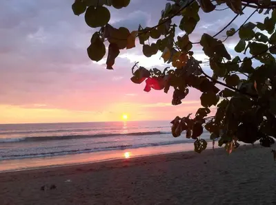 a sunset on a beach with the ocean at Bamboo Relax Uvita in Uvita