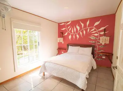 a bedroom with a bed and a red wall at Private Villa with Pool near Manuel Antonio beach in Naranjito