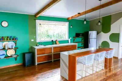 a green kitchen with a counter and a sink at Private Villa with Pool near Manuel Antonio beach in Naranjito