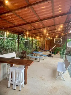 a patio with a table and chairs and a hammock at Private Villa with Pool near Manuel Antonio beach in Naranjito