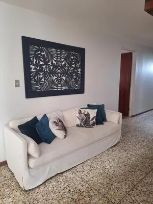 a white couch with pillows on it in a living room at Acogedora y amplia habitación en La Tropicana in Alajuela City