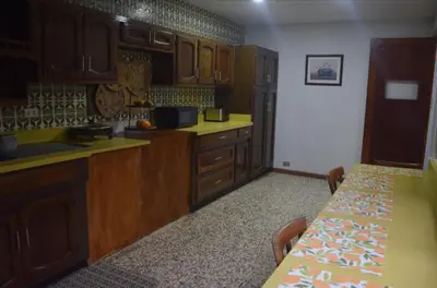 a kitchen with wooden cabinets and a table in it at Acogedora y amplia habitación en La Tropicana in Alajuela City
