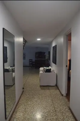 a living room with a white couch and a table at Acogedora y amplia habitación en La Tropicana in Alajuela City