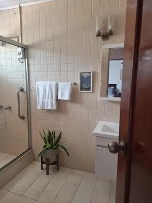 a bathroom with a shower and a plant in it at Acogedora y amplia habitación en La Tropicana in Alajuela City