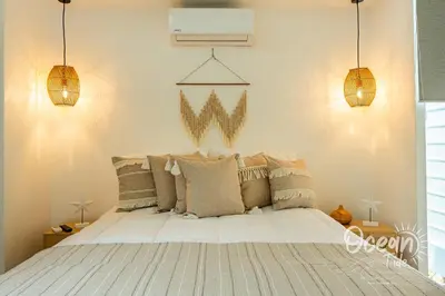 a bedroom with a large white bed with pillows at Oceantide Playa Hermosa in Playa Hermosa