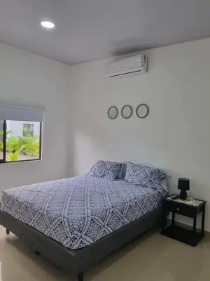 a white bedroom with a bed and a window at Villas Azul in Tamarindo