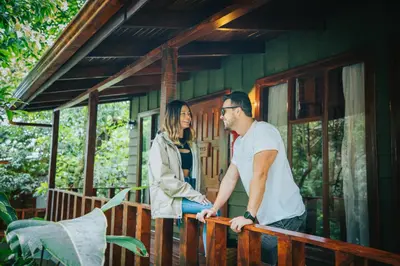 a man and woman standing on the porch of a house at Jaguarundi Jungle Lodge - Monteverde in Monteverde Costa Rica