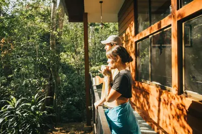 a man and a woman standing outside of a house at Jaguarundi Jungle Lodge - Monteverde in Monteverde Costa Rica