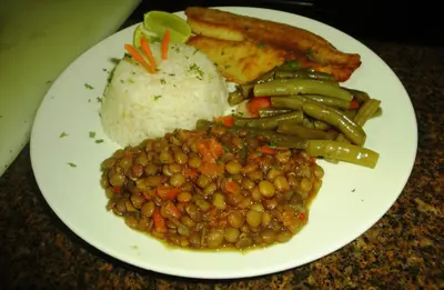 a white plate of food with beans and rice at Selva Verde Lodge in Sarapiquí