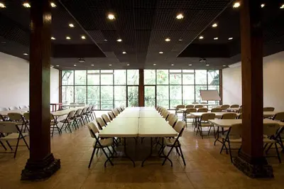 a large room with tables and chairs and windows at Selva Verde Lodge in Sarapiquí