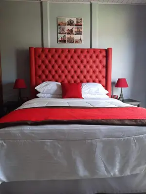 a large bed with a red headboard in a bedroom at Hotel Boutique Malibu Los Sueños in Tigre