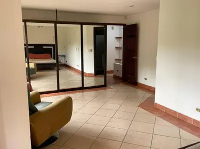 a living room with a couch and a mirror at Comparte con la Naturaleza in Escazu