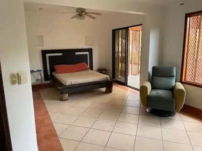 a bedroom with a bed and a chair and a fan at Comparte con la Naturaleza in Escazu