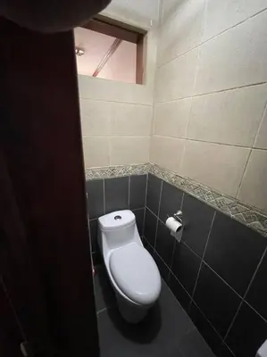 a bathroom with a toilet in a tiled room at Comparte con la Naturaleza in Escazu