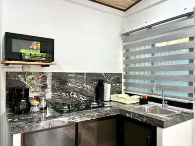 a kitchen with a sink and a tv on a wall at `Luci's Home' in Uvita