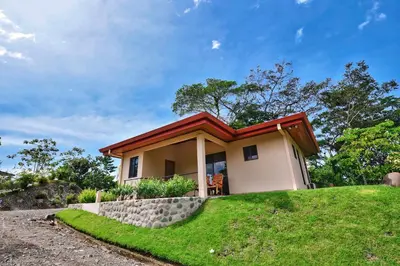 a small house on top of a grassy hill at Villa Romancing The Stone in Ojochal