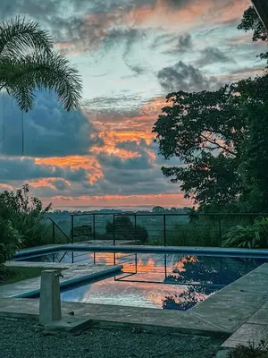 a swimming pool with a sunset in the background at Villa Romancing The Stone in Ojochal