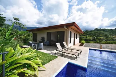 a house with a swimming pool next to a house at Villa Romancing The Stone in Ojochal
