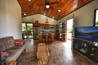 a living room with a couch and a flat screen tv at Villa Romancing The Stone in Ojochal