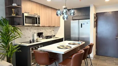 a kitchen with a refrigerator and a table with chairs at Luxury apartment 10 min to Airport Be Cariari Condo #402 in La Asunción