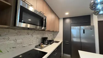 a kitchen with a stainless steel refrigerator and a microwave at Luxury apartment 10 min to Airport Be Cariari Condo #402 in La Asunción