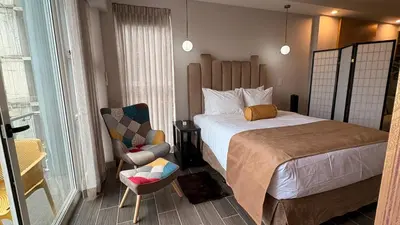 a hotel room with a bed and a chair at Luxury apartment 10 min to Airport Be Cariari Condo #402 in La Asunción