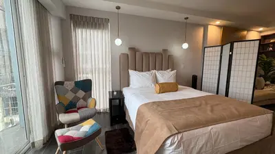 a small bedroom with a bed and a chair at Luxury apartment 10 min to Airport Be Cariari Condo #402 in La Asunción