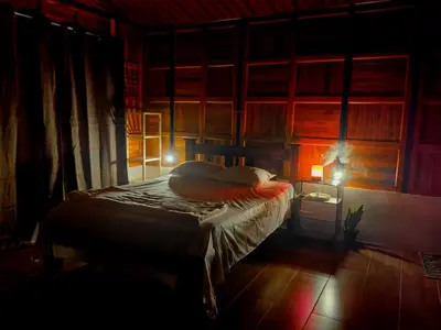 a bedroom with a bed and a lamp in it at Cabaña Colibri #2 in Quesada