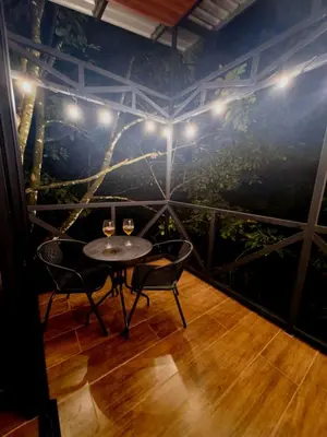 a room with two chairs and a table with two glasses of wine at Cabaña Colibri #2 in Quesada