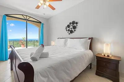 a bedroom with a bed with a view of the ocean at Majestic Oceanview Condo with King Beds in Coco
