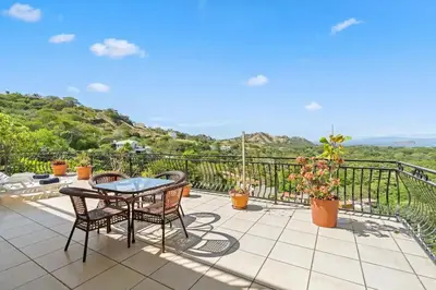 a patio with a table and chairs on a balcony at Majestic Oceanview Condo with King Beds in Coco