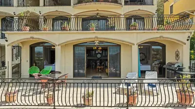a building with a balcony with chairs and tables at Majestic Oceanview Condo with King Beds in Coco