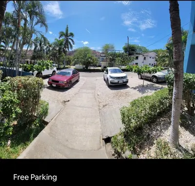 three cars parked in a parking lot with palm trees at Renovated apartment in Las Palmas in Coco